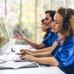 pbx & voip blog posts - woman in blue at call center with coworkers